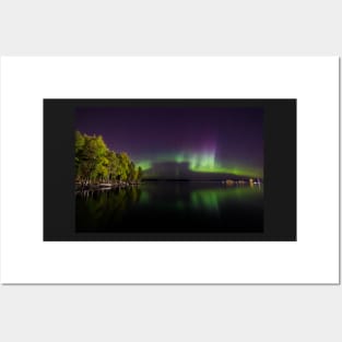 Northern lights glowing over lake in Finland Posters and Art